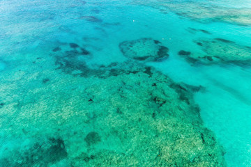 Fototapeta na wymiar Aerial view of clear ocean water with colar reefs. Nature summer background