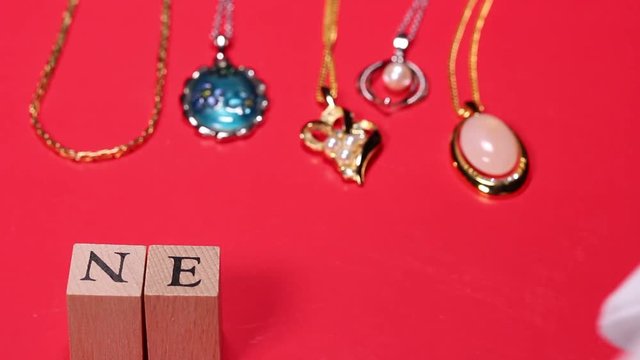 宝飾品とNECKLACEの文字を並べる手