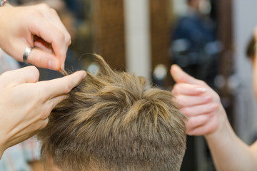Fototapeta premium Make a fashionable haircut for children in the barbershop