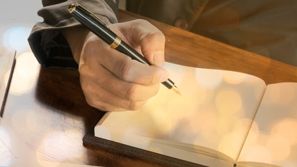 Hand holding a pen for sign business document notebook