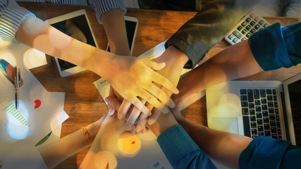 People in team harmonious hand meeting with worm light