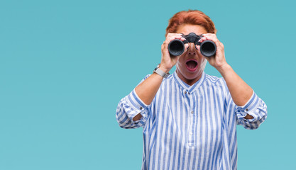 Senior caucasian woman looking through binoculars over isolated background scared in shock with a surprise face, afraid and excited with fear expression