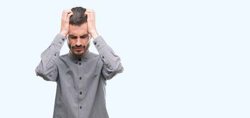 Young hipster man suffering from headache desperate and stressed because pain and migraine. Hands on head.