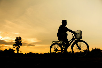 Obraz premium A boy fitness silhouette sunrise cycling workout wellness concept