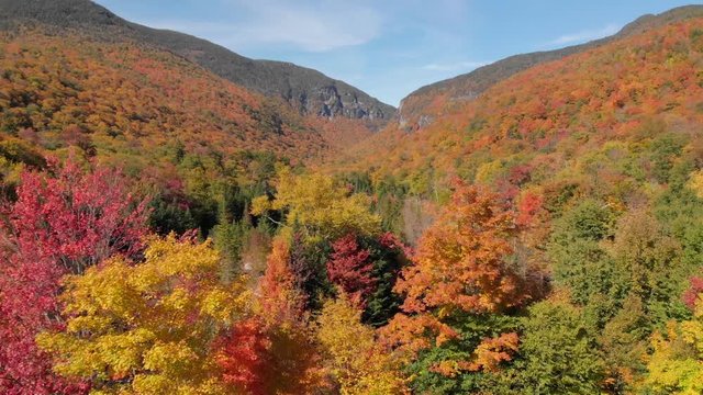 Aerial drone shot of fall foliage and hiking trails through Smugglers Notch, Vermont, USA.
