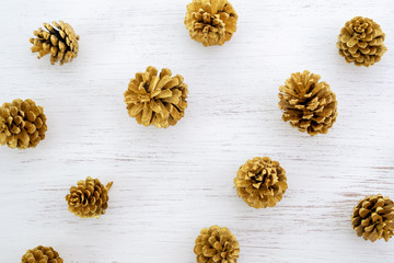 Merry Christmas background - pattern of pine cones gold colour on white background. creative flat lay design.