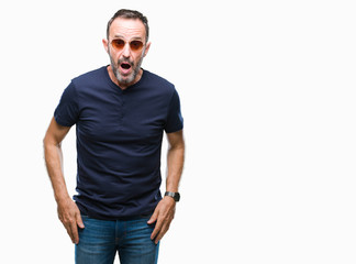 Fototapeta premium Middle age hoary senior man wearing sunglasses over isolated background afraid and shocked with surprise expression, fear and excited face.