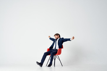 a man in a suit is stretched while sitting on a chair