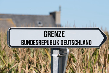 Ein Schild weis auf die Richtung zu der deutschen Grenze