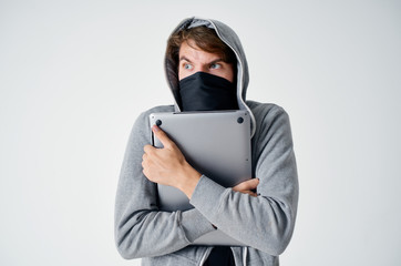 a man in a mask hood hugged laptop