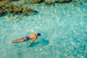Snorkeling in crystal clear water in Perhentian Island.