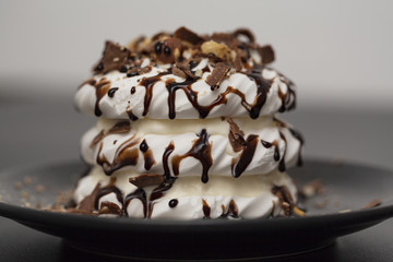 Meringue dessert with chocolate sauce, chocolate, nuts and cream.