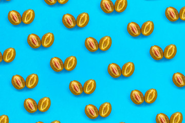 Food pattern of halves of ripe blue plum with bone on bright turquoise paper, minimalism style, top view
