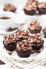 Chocolate cupcakes decorated coffee cheese cream on a white plate