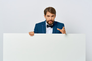 a man in a suit is standing behind a big white drawing paper mockup