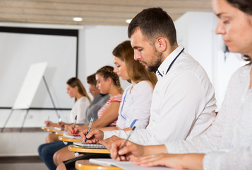 Obraz premium Side view of young people in auditorium