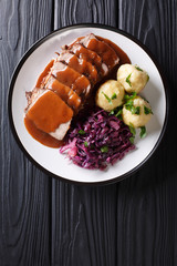 Festive German full dinner Sauerbraten - beef stew with gravy served with potato dumplings and red...