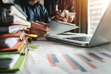 Team business meeting presentation. Hand businessman working project in modern office.Laptop computer and tablet and smart phone on white desk in morning light