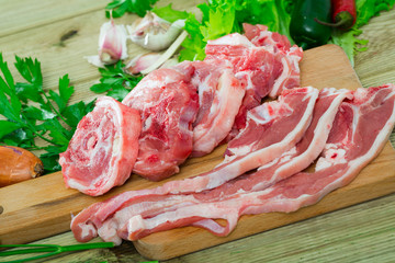 Fresh slices of mutton and vegetables assortment on natural wooden desk