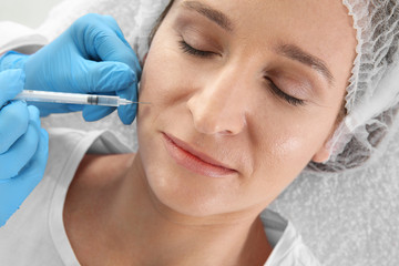 Woman getting facial injection in clinic. Cosmetic surgery concept