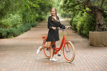 Beautiful woman in casual outfit with bicycle outdoors