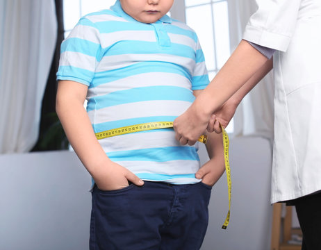Doctor measuring overweight boy in clinic
