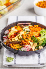 Vegan Buddha bowl with baked vegetables, chickpeas, hummus and tofu.