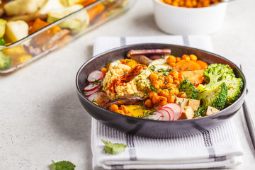Vegan Buddha bowl with baked vegetables, chickpeas, hummus and tofu.