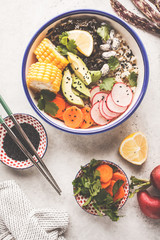 Flat lay vegan poke bowl with brown rice, sea kale and vegetables.