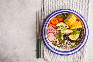 Vegan poke bowl with brown rice, sea kale and vegetables.