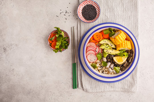 Vegan poke bowl with brown rice, sea kale and vegetables.