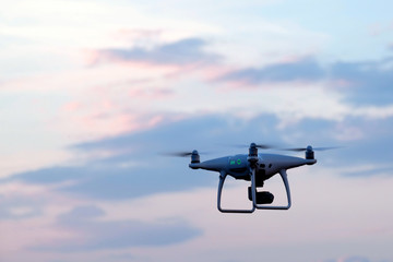 Unmanned aerial vehicle in the sky with clouds. Morning or evening flight quadcopter. Aerial video footage. Copy space.