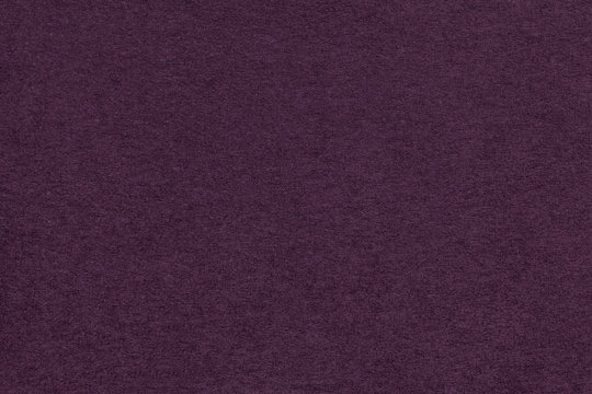 Texture of old dark purple paper closeup. Structure of a dense cardboard. The violet background