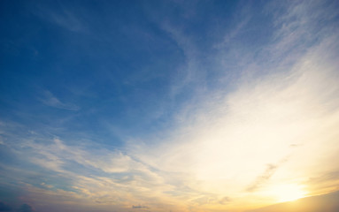 Obraz premium Błękitne i pomarańczowe światło słońca przez chmury na niebie