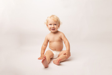 Infant child baby girl in diaper laughs happy looking at the camera isolated on a white background