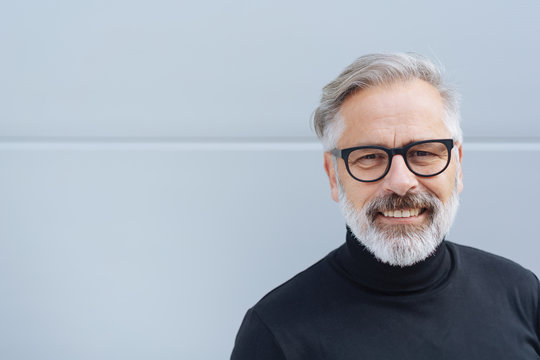 &auml;lterer mann mit brille lacht in die kamera