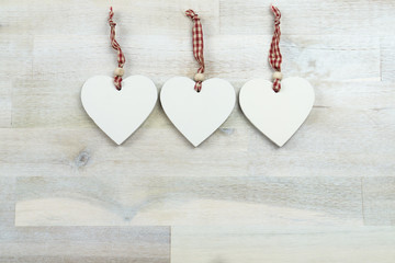 Three hearts of wood on wooden background, copy space
