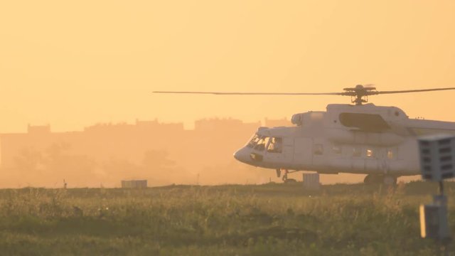 Helicopter is taxiing on the airfield before take off at sunset