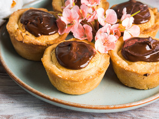 Cakes with frangipane, cherry jam and chocolate frosting. Romantic table setting with flowers. Mother's day card