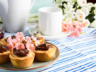 Cakes with frangipane, cherry jam and chocolate frosting. Romantic table setting with flowers. Mother's day card