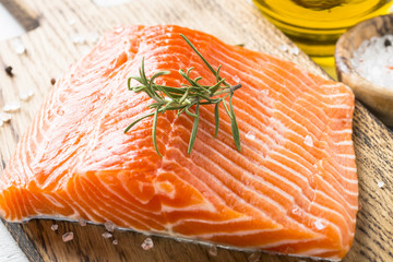 Uncooked salmon fillet with lemon sea salt and rosemary on white
