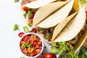 Mexican pork tacos with vegetables and salsa.