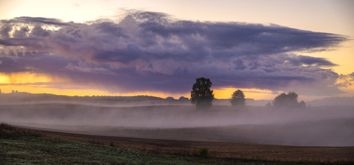 Fototapeta premium beautiful, dramatic sky over an autumn field enveloped in the morning mists-Poland, Drawskie Lakeland