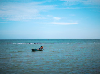 one small fishing boat on the blue sea and clear sky