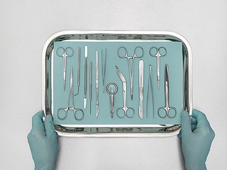 Person holding tray with surgical equipment