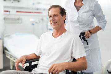 I trust my doctor. Portrait of paralyzed patient in hospital room looking away with smile