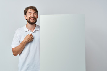 happy man holding white sheet of paper in his hand mock up , poster