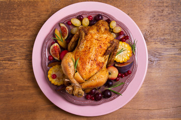 Chicken with fruits, vegetables and berries: apples, figs, grapes, plums and cranberries. View from above, top studio shot