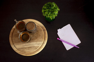 Obraz na płótnie Canvas Coffee cup on the table, with pen,Black background
