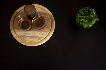 Coffee cup with ornamental tree in the upper corner of the image.